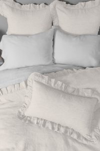 Amity home basillo duvet cover   ivory linen duvet cover with ruffled shams and lumbar pillow on a styled bed