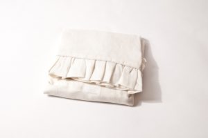 Amity home basillo duvet cover in ivory folded to show its elegant ruffled edge and soft linen texture
