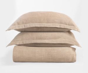 Amity home jerome duvet cover in natural beige stacked with two matching shams showing a woven linen like texture
