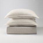 Amity home rayden duvet cover set in natural beige showing a folded duvet and two stacked pillow shams with a subtle woven texture