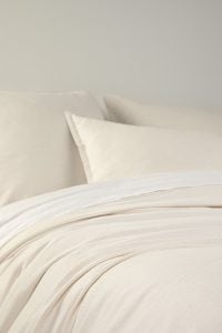 Amity home pure duvet cover   ivory luxury bedding with a subtle textured weave softly draped on a bed