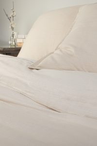 Amity home pure duvet cover   ivory luxury bedding with a subtle woven texture styled on a bed with matching pillows