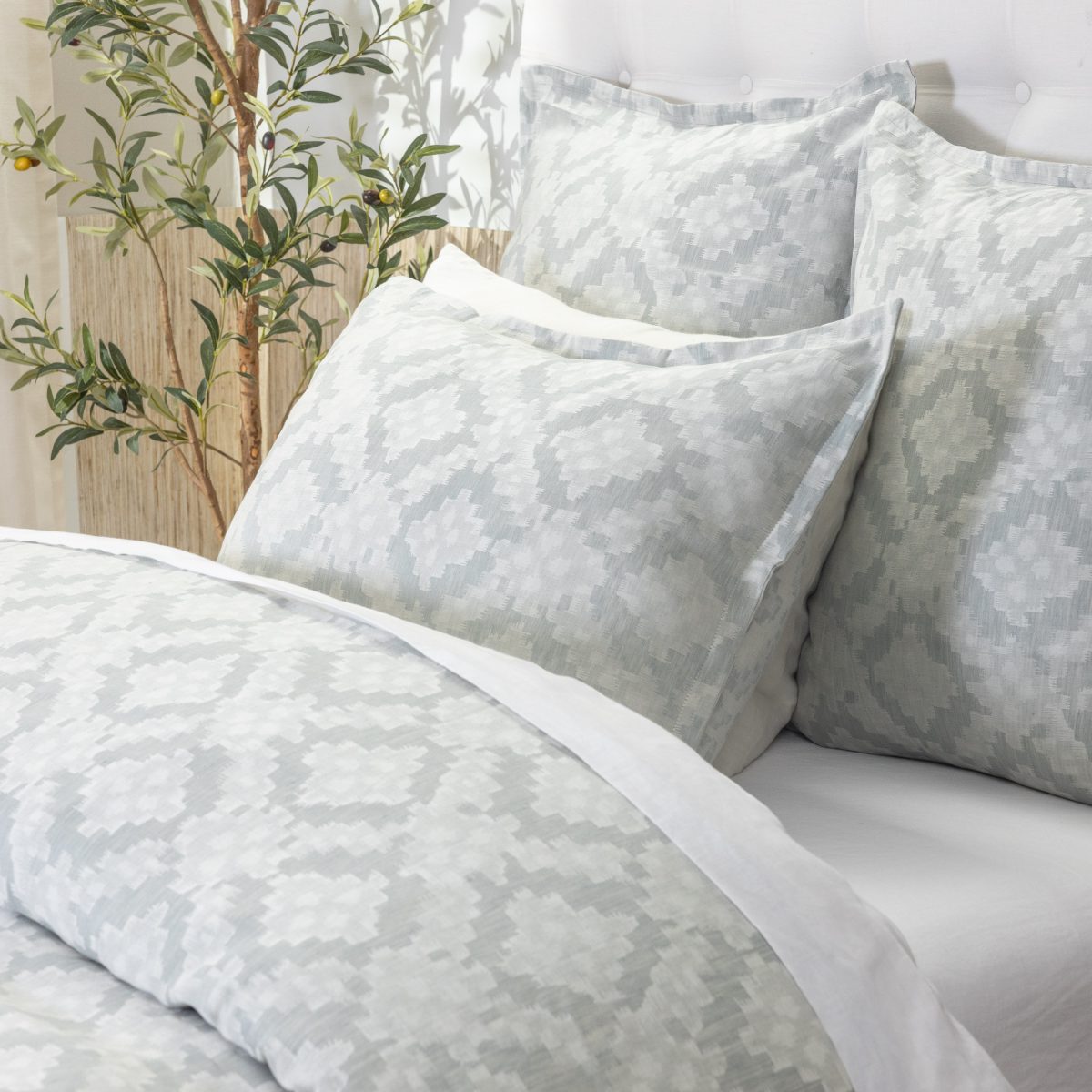 Amity home dawson french ikat duvet cover and shams in sea glass and white featuring a subtle geometric pattern on a styled bed