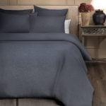Amity home damara duvet cover in steel blue with a subtle woven texture styled on a bed with matching shams