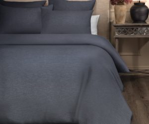 Amity home damara duvet cover in steel blue with a subtle woven texture styled on a bed with matching shams