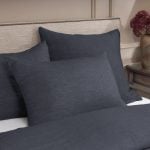 Amity home damara duvet cover and pillows in steel blue with a visible linen texture styled on a luxury bed