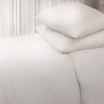 Amity home damara duvet cover in ivory styled on a bed with two stacked pillows showing soft natural fabric texture