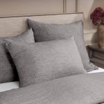 Amity home damara duvet cover and pillows in soft grey chambray showcasing fine weave texture on a luxurious bed