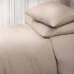 Amity home damara duvet cover   natural beige linen duvet cover and matching pillows on a bed showcasing its subtle textured weave