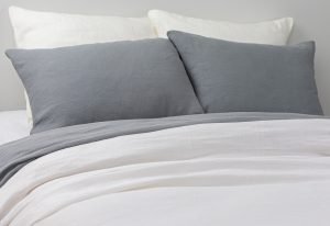 Amity home damara duvet cover in neutral grey styled on a bed with matching grey pillows and white linen bedding