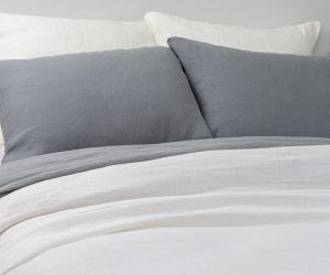 Amity home damara duvet cover in neutral grey styled on a bed with matching grey pillows and white linen bedding