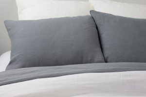 Amity home damara neutral grey duvet cover and pillows featuring a soft textured linen like fabric on a bed