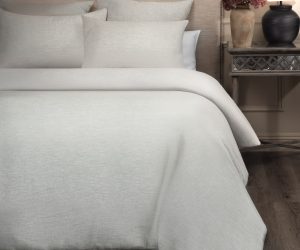 Amity home damara duvet cover in sea glass with a subtle linen like texture styled on a bed with matching pillow shams
