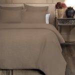 Amity home damara duvet cover in walnut brown styled on a bed with matching shams showing its subtle woven texture