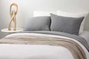 Amity home damara duvet cover in neutral grey with a soft textured finish styled on a bed with matching pillows and a beige throw
