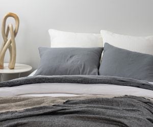 Amity home damara duvet cover in neutral grey linen styled on a bed with matching pillows and a textured throw