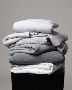 Amity home damara duvet cover   stack of folded neutral grey linen bedding showcasing soft varied grey tones