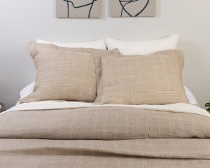 Amity home zach linen duvet cover and shams in natural beige with a subtle blue and white plaid pattern on a styled bed