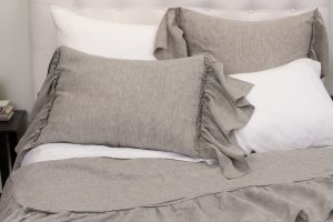Amity home caprice duvet cover and matching shams in grey chambray with elegant ruffled edges styled on a bed
