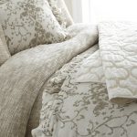Amity home riva duvet cover in natural beige featuring a visible textured weave on a styled bed with patterned pillows
