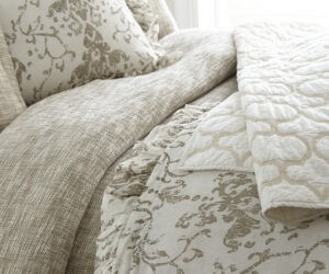Amity home riva duvet cover in natural beige featuring a visible textured weave on a styled bed with patterned pillows
