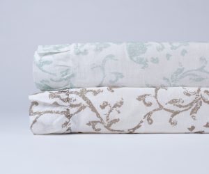 Amity home riva duvet cover   rolled natural linen duvet with brown scrolling floral pattern stacked with a blue patterned duvet