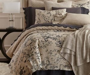 Amity home le poet linen duvet cover   steel blue ornate floral pattern on natural beige linen styled on a luxurious bed