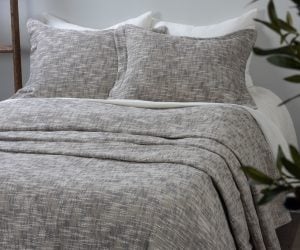 Amity home evol duvet cover   charcoal textured woven bedding with two matching shams on a bed