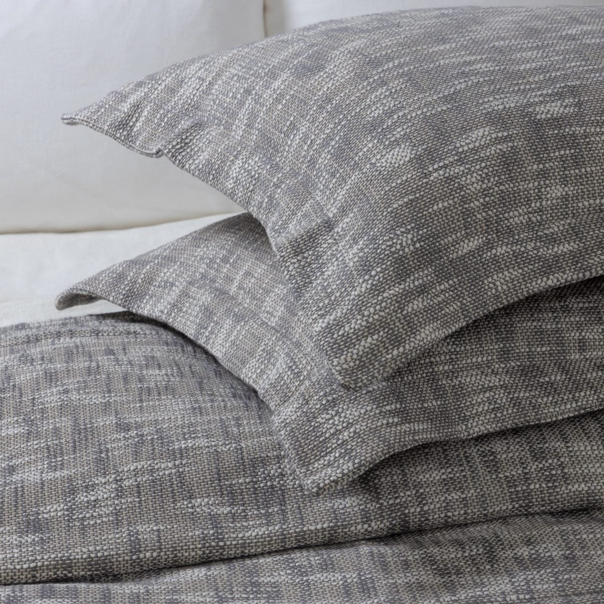 Amity home evol duvet cover and matching pillows in charcoal with a textured speckled weave styled on a bed