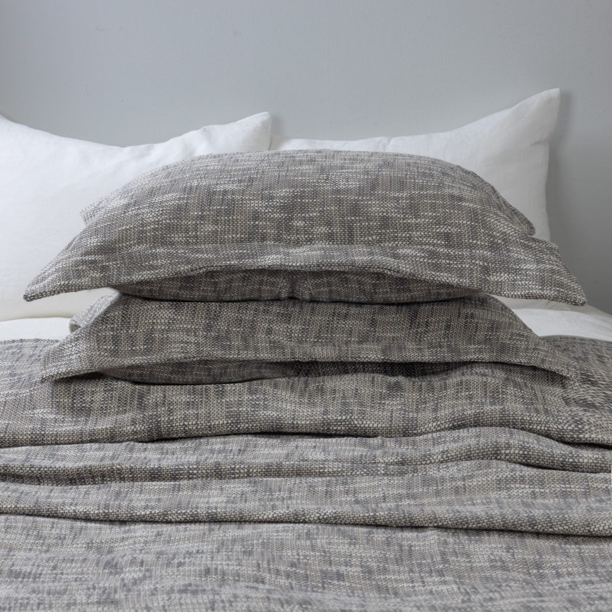 Amity home evol duvet cover and shams charcoal with a textured woven melange pattern styled on a bed