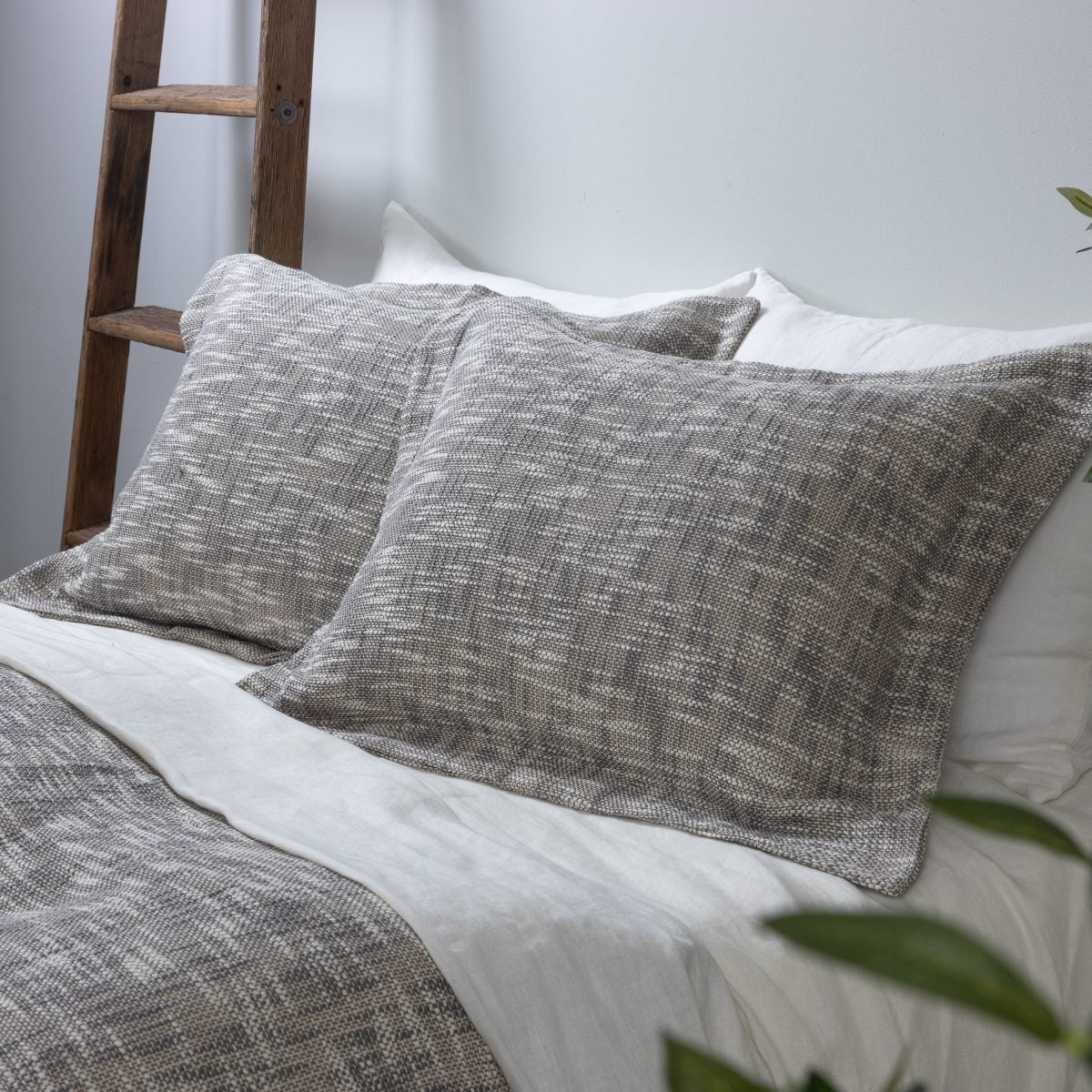 Amity home evol duvet cover and shams in charcoal featuring a textured flecked weave on a styled bed