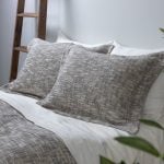 Amity home evol duvet cover and shams in charcoal featuring a textured flecked weave on a styled bed