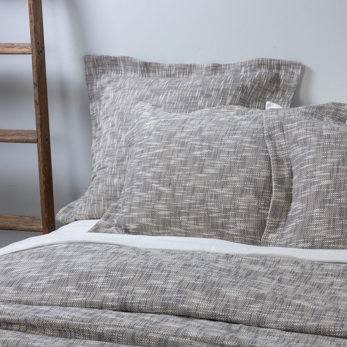 Amity home evol duvet cover and shams in charcoal and light grey heathered woven texture on a bed
