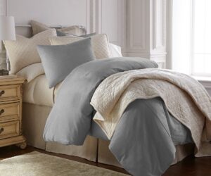 Amity home lia rayon velvet duvet cover   limestone grey velvet bedding draped on a luxurious bed with cream quilted layers