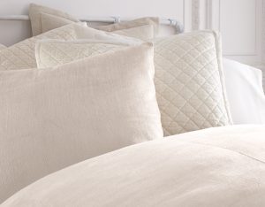Amity home lia rayon velvet duvet cover in oyster draped on a bed with layered pillows and quilted accents