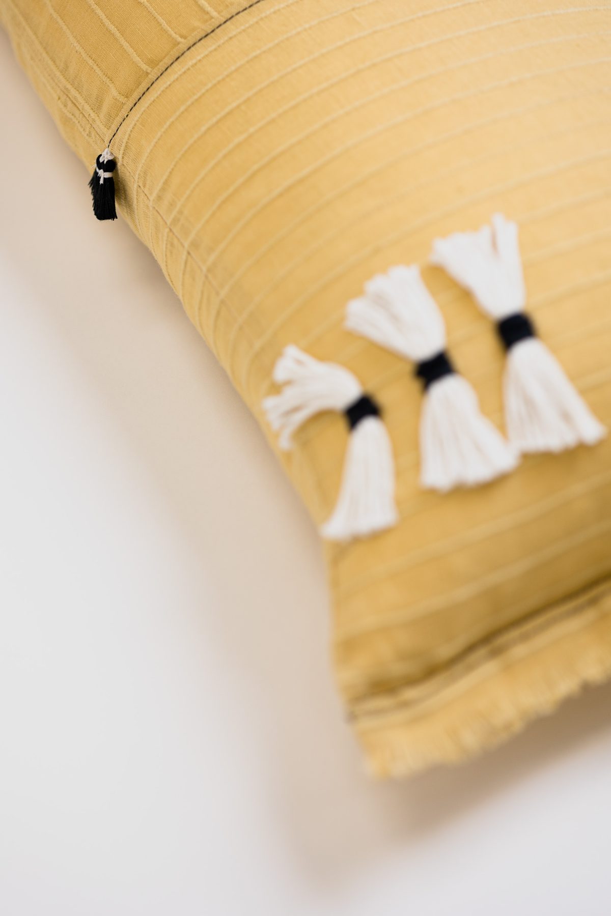 Amity home cambria bolster in ochre   white tassels