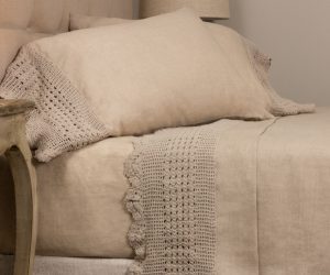 Amity home eveline linen natural crochet sheet set   natural beige linen with intricate crochet trim on pillow and sheet styled on a bed
