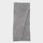 Woven black and white checkered blanket folded with a corner turned over to show texture