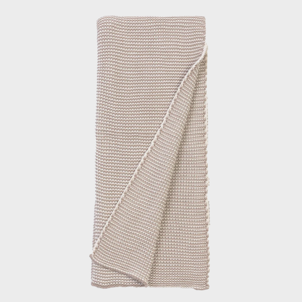 Kd1000nth | Amity Home Beige knitted throw blanket folded neatly with a corner draped over the edge on a white background