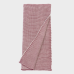 Red and white striped towel neatly folded with a corner lifted to show the weave tail end