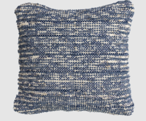 Square decorative pillow with a blue and cream woven pattern on a textured surface
