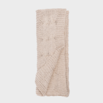 Beige chunky knit scarf folded with a cable knit pattern and ribbed edges