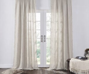 Beige sheer curtains on glass french doors a cozy living room with a dark wood floor nearby and soft textiles nearby