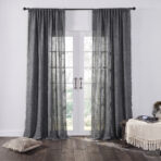 Gray sheer curtains frame white french doors letting in soft outdoor light