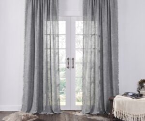 Tall white framed french doors with sheer gray curtains allowing light to filter in view of greenery outside