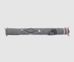 Rolled gray woven towel with pink tassels at both ends and diamond embroidery in the center