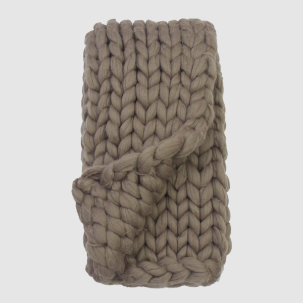Thick beige chunky knit scarf folded with a knot in the center. Intended for winter warmth and texture. Or: A knitted beige scarf with oversized yarn stitches, tied in the middle.
