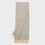 Light gray scarf with cream fringe along both ends laid flat with one corner slightly folded