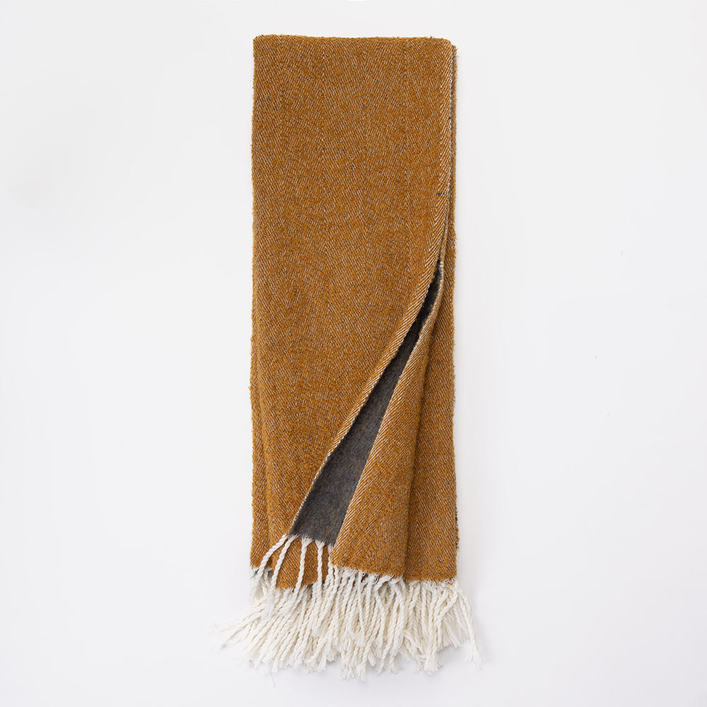 Sm104hth | Amity Home Brown woven scarf with white fringe laid flat one corner folded to show a gray underside
