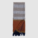 Woven scarf with gray and brown striped sections and a rust geometric block near the bottom navy fringe at the ends